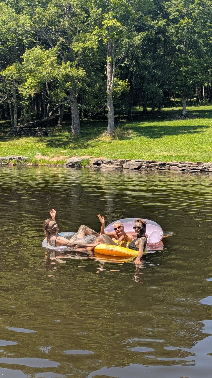 Three people relaxing on pool floats in the pond